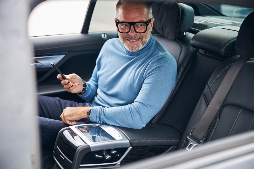 Relaxed man enjoying a pre-booked airport taxi with Ovova in South West London